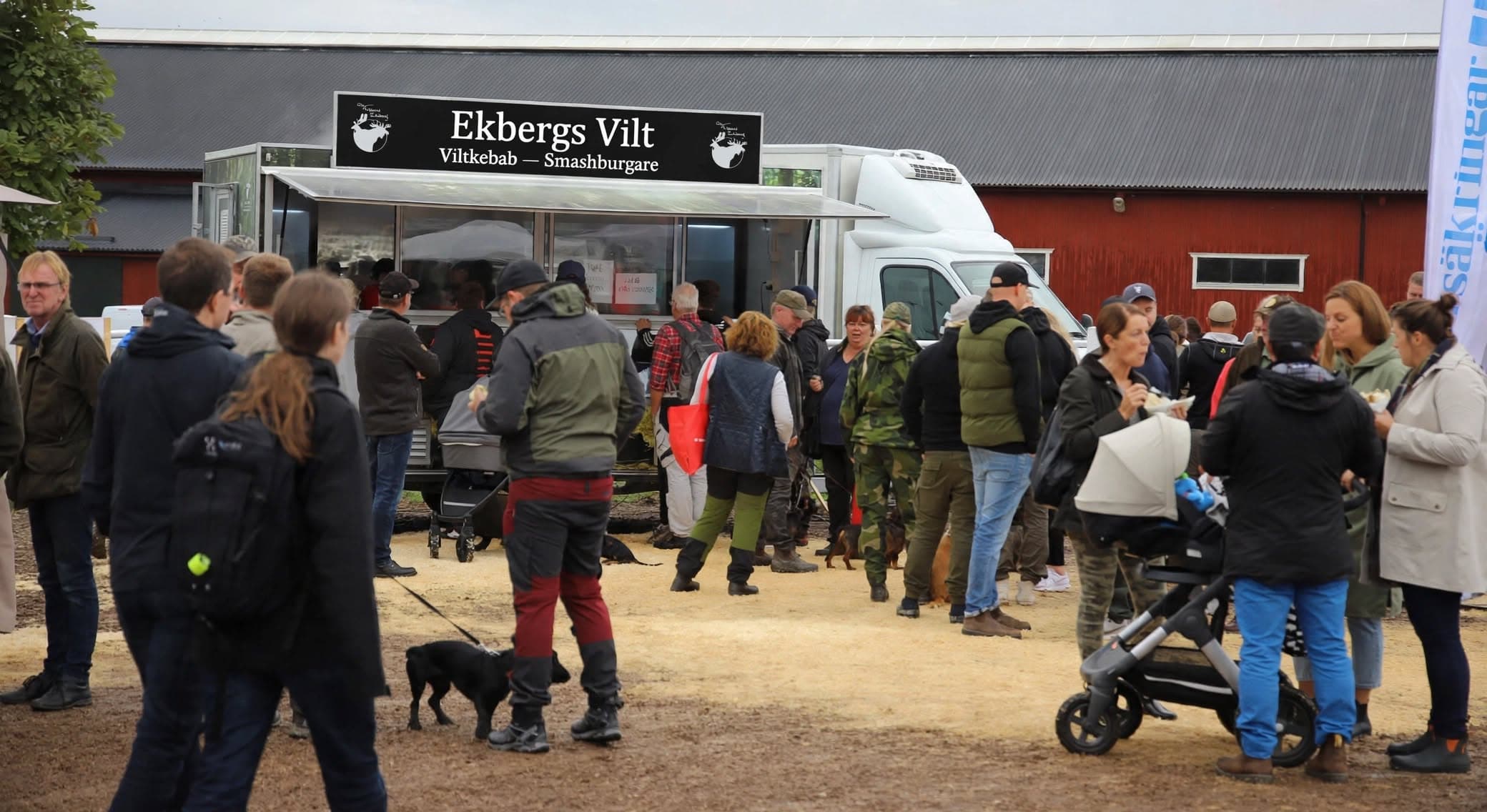 Lång kö av besökare framför Ekbergs food trailer på en mässa