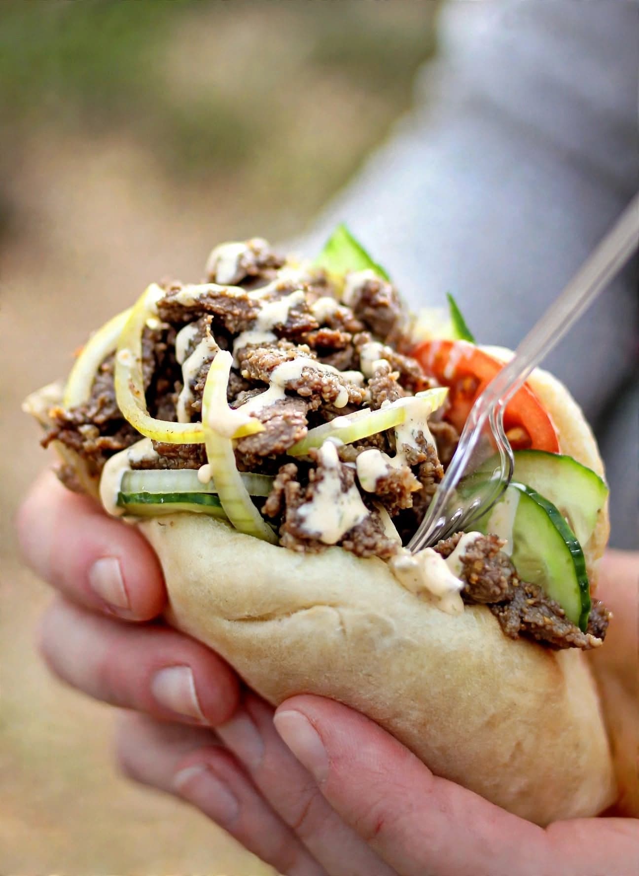 Viltkebab på kronhjort i pitabröd med gurka, tomat, lök och sås, hållen i handen